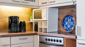 A kitchen with a microwave, coffee maker, and oven.