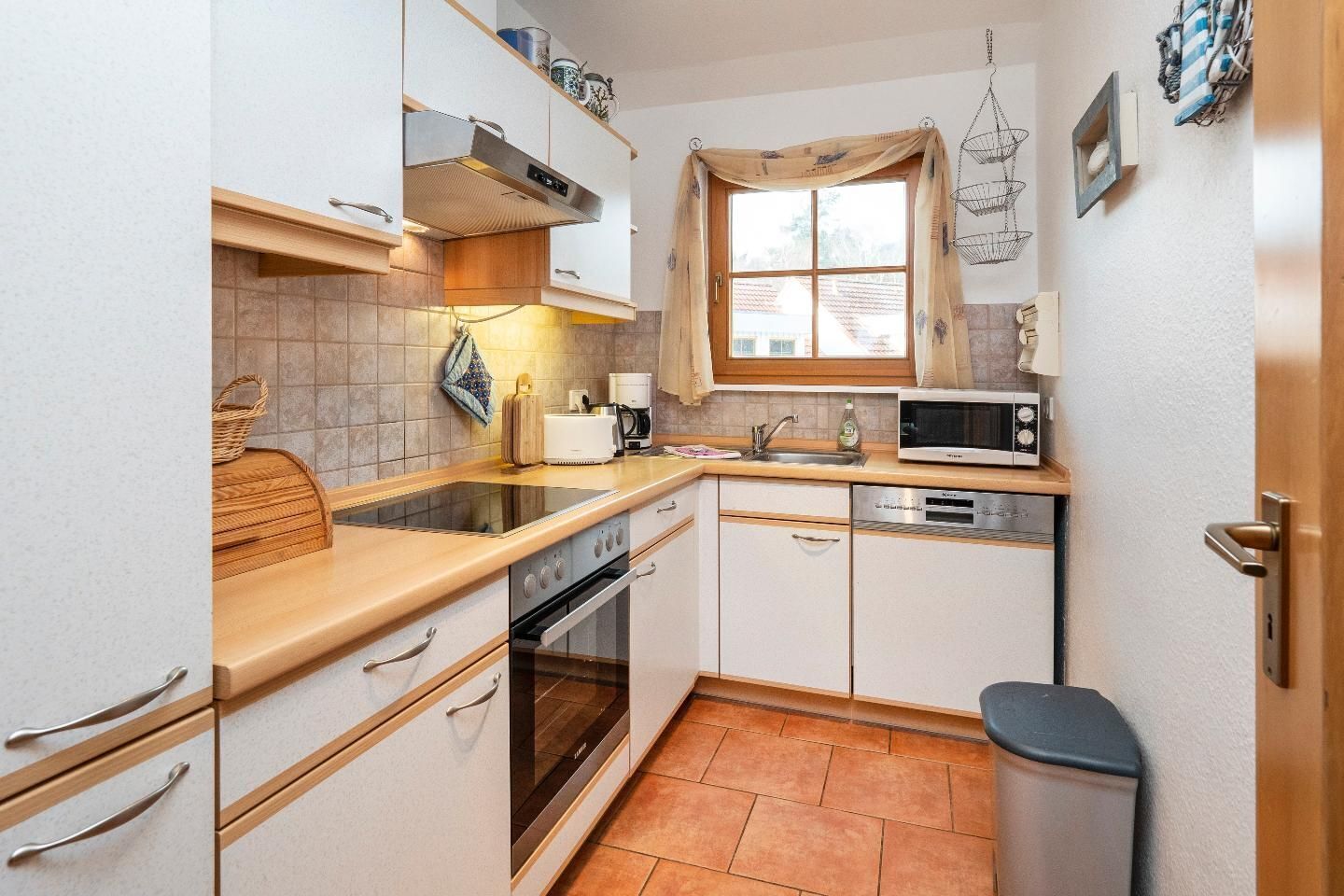 A compact kitchen with a stove, microwave, and sink.