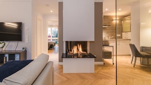 Una sala de estar moderna con chimenea, televisor y sofá.