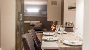 Un comedor con una mesa dispuesta para cuatro personas, incluyendo platos, cubiertos y vasos.