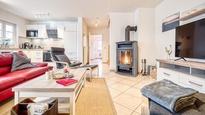 Un salon moderne avec une cheminée, un canapé, une table basse et un téléviseur.
