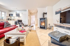 A modern living room with a fireplace, a sofa, a coffee table, and a TV.