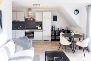 En moderne lejlighed med køkken, spiseområde og opholdsstue.