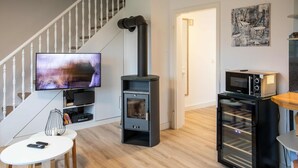 A modern living room with a fireplace, a television, and a microwave. - Vacation apartment Wrixumer Marsch - Located directly on the marsh (Wrixum)