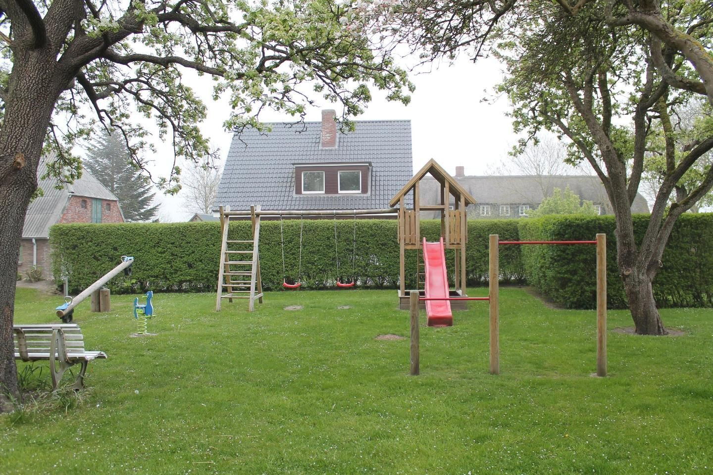 A playground with swings, a slide, and a climbing structure.