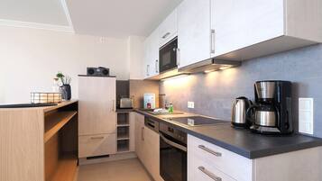 Een koelkast, een oven, een kookplaat, een vaatwasser