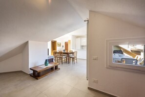 A spacious room with a dining area, a window with a view, and a built-in bench.