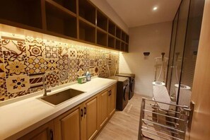 A kitchen with patterned backsplash, stainless steel sink, and built-in appliances. - Magnotel Hotel (Yan'an Baota Mountain Hundred Meter Avenue) (Yan'an)