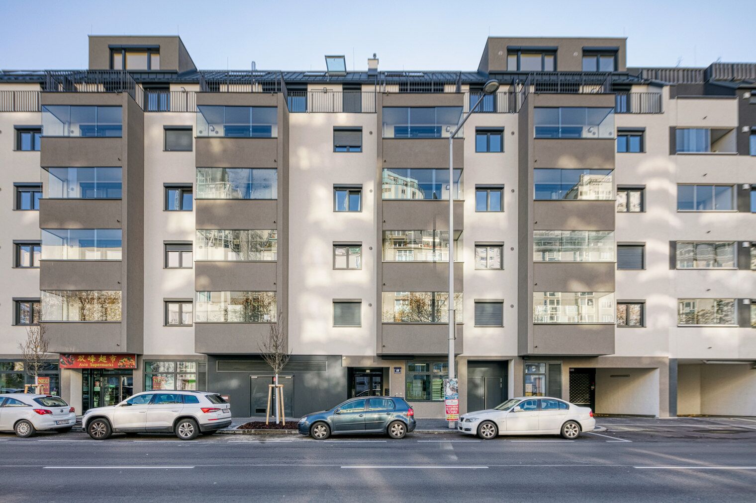 A multi-story residential building with a modern design, featuring balconies and large windows.