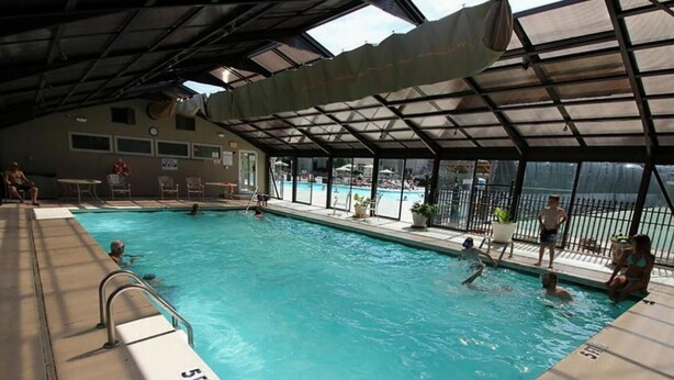 Une piscine intérieure dotée d’un toit abrité, d’une eau claire et d’un poste de surveillance pour le sauveteur.
