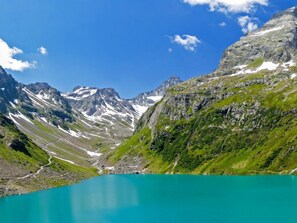 A mountain landscape with a turquoise lake, rocky terrain, and snow-capped peaks. - Silvretta by Interhome (Kappl)