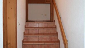 Un escalier avec des rampes en bois et une porte sur le côté gauche.