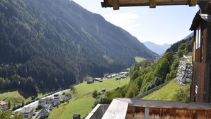 Une cabane en bois offrant une vue sur une vallée et des montagnes.