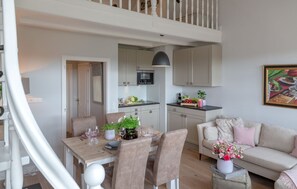Un appartement moderne comprenant un coin repas, une cuisine et un salon.