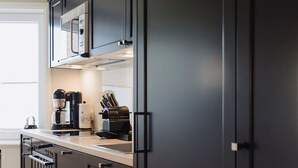 A modern kitchen with dark cabinetry, a built-in oven, and a coffee maker. - Poseidon - Poseidon: A luxurious retreat for 4 sea lovers (Sylt)