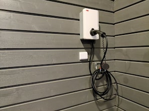 A wall-mounted electrical outlet with a power cord plugged in, set against a grey wall with horizontal paneling. - Vuokatin loiste 9 a 3 by Interhome (Sotkamo)