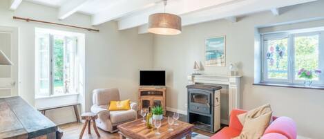A living room with a fireplace, a sofa, a coffee table, and a television.