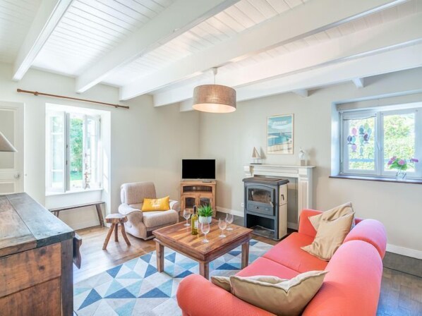 A living room with a fireplace, a sofa, a coffee table, and a television.