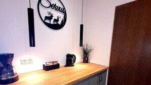 Una cocina moderna con encimera de madera, armarios grises y un cartel en la pared.