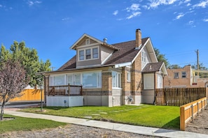 A two-story house with a brick exterior, large windows, and a well-maintained lawn. - Beautiful Restored Victorian Home (Pueblo)