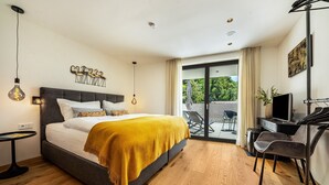Une chambre à coucher moderne avec un lit, une table de chevet et un bureau avec une chaise.