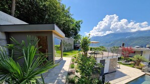 A modern house with a pool, garden, and mountain view. - Apartment "Videre Lodge Wasserfall" with Mountain View, Wi-Fi & Terrace (Gargazon)