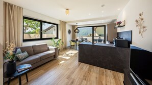 Een moderne woonkamer met een bank, eettafel en televisie.