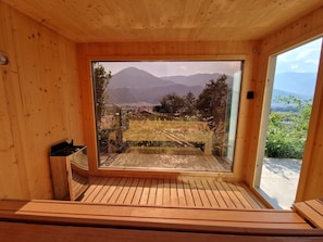 A wooden interior with a large window offering a view of a mountainous landscape.