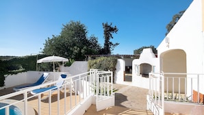 A pool area with lounge chairs, a white fence, and a clear blue sky. - "Vila Caracol" with Pool, Tennis Court, A/C & Wi-Fi (Guia)