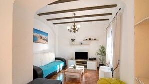 A living room with a sofa, a coffee table, a TV, and a plant. - "Vila Caracol" with Pool, Tennis Court, A/C & Wi-Fi (Guia)