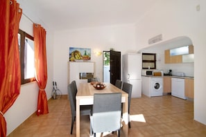 Un comedor con mesa, sillas y un cuadro en la pared.