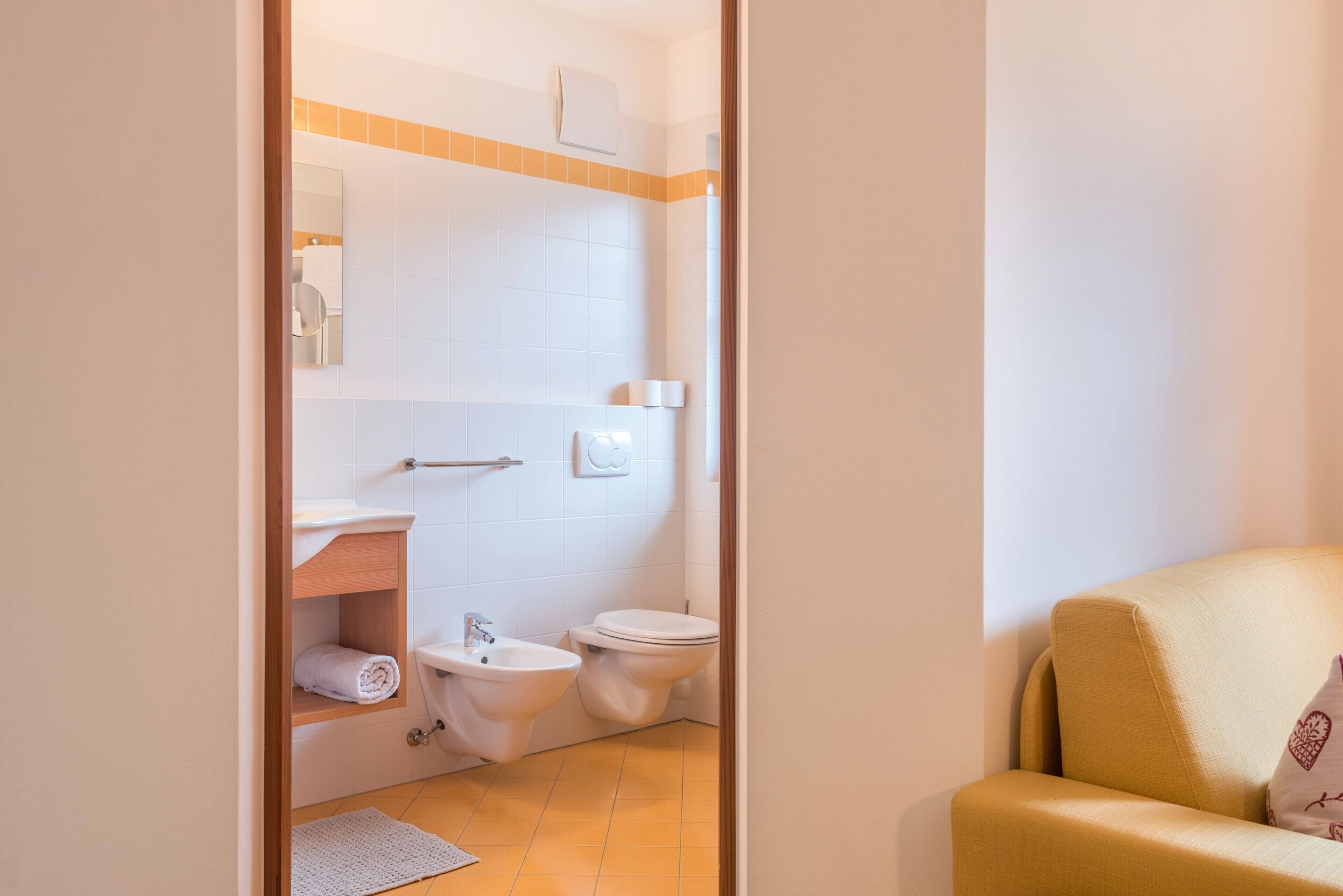 A bathroom with a toilet, bidet, and sink.