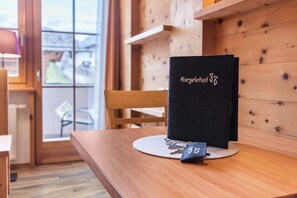 A wooden table with a black folder labeled 'Riegelehof' and a small keychain.