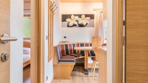 Ein kleines Zimmer mit einer Sitzbank, einem kleinen Tisch und einer Wandleuchte.
