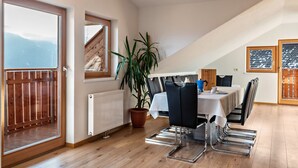 A dining area with a table, chairs, a potted plant, and a view of the outdoors. - Apartment 'Kehrerhof - Panorama' with Mountain View, Balcony & Wi-Fi (St. Lorenzen)