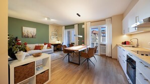 A modern apartment with a dining area, kitchen, and living room. - Apartment Huita with Balcony and Wi-Fi (Bozen)