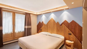A bedroom with a bed, wooden headboard, curtains, and a nightstand. - Mountain Apartment - Rasia Residence Relax (Livigno)