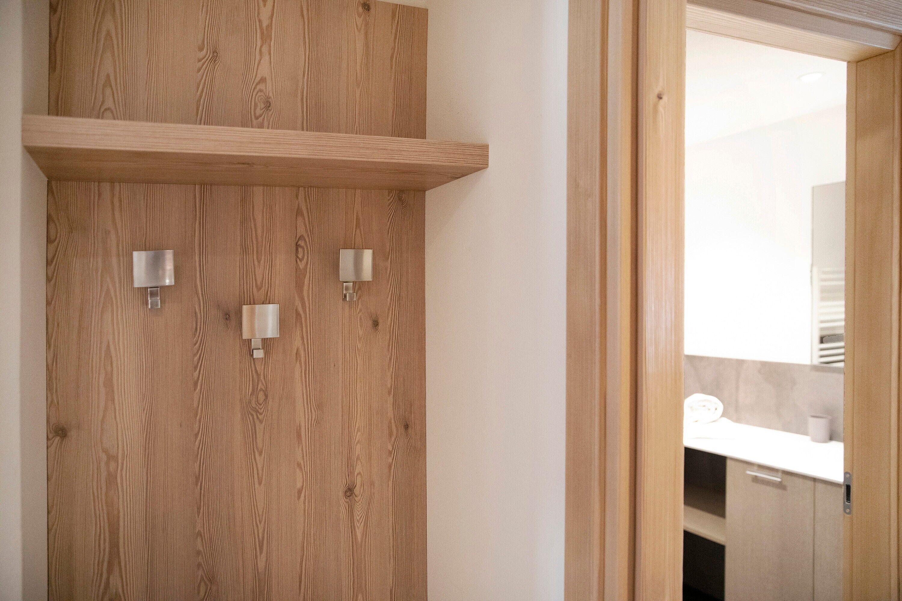 Une porte en bois, avec deux appliques murales et une étagère au-dessus.