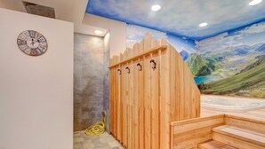 A wooden sauna with a view of a mountainous landscape through a mural.