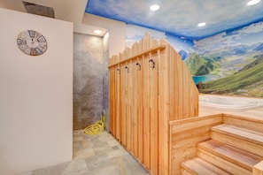 A wooden sauna with a view of a mountainous landscape through a mural.