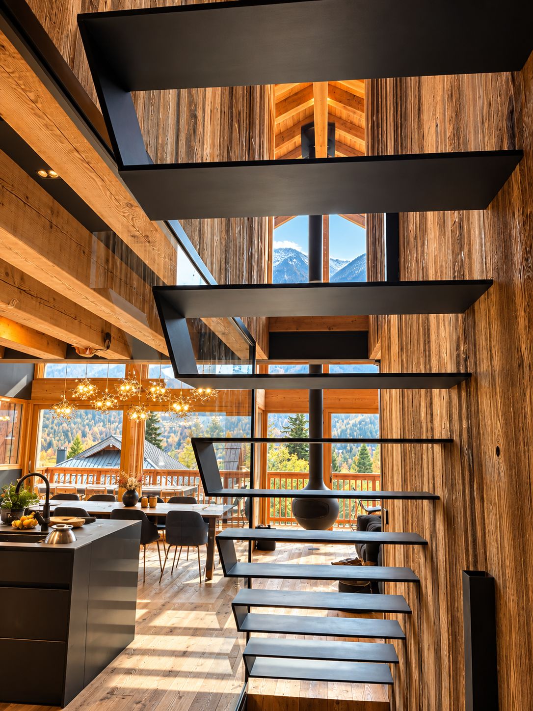 A modern interior with wooden paneling, a kitchen area, and a dining space with a view of mountains.