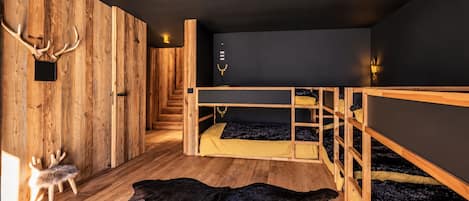 A room with wooden bunk beds, a fur rug, and antlers on the wall.