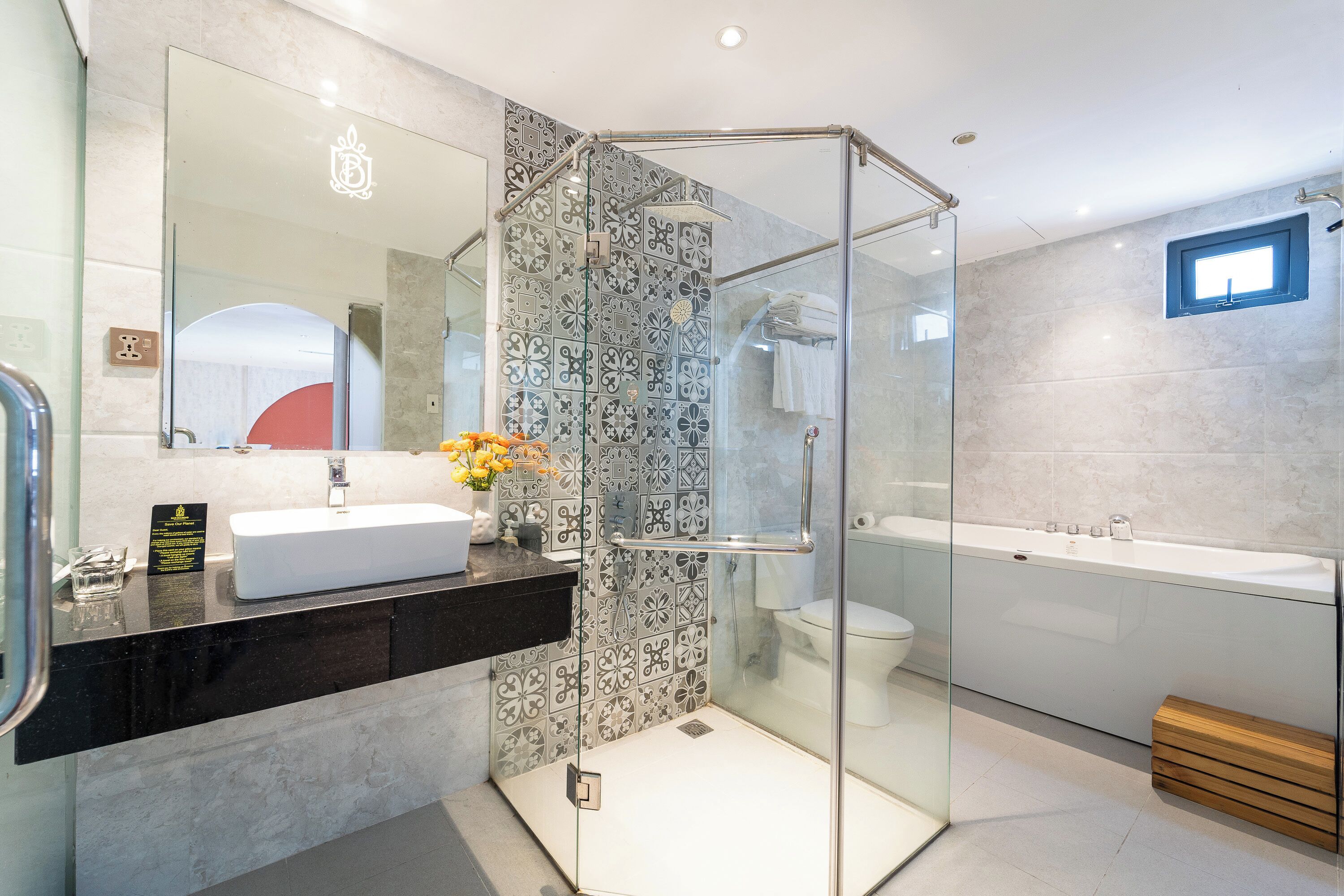 A modern bathroom with a glass-enclosed shower, a white sink, and a large bathtub.