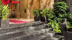 A modern interior with a wooden ceiling, a red carpeted entrance, and a staircase leading to a higher level.