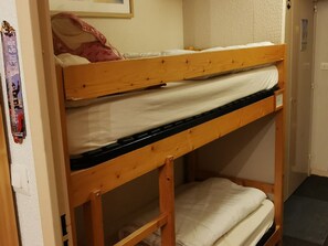 Ein Stockbett mit einer unteren Schlafstelle und einer Matratze auf der oberen Schlafstelle.