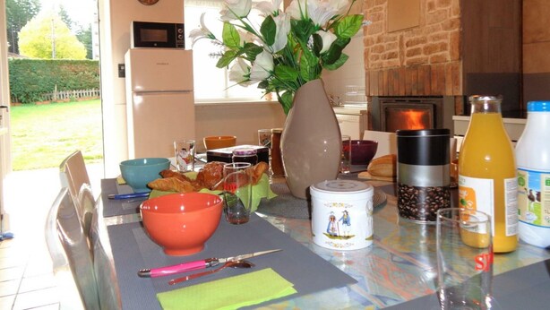 A kitchen with a stone wall, a wooden ceiling, and a view of a garden. - Cozy cottage with pets allowed and wifi in Saint-Jean-la-Vêtre (Saint-Jean-la-Vêtre)