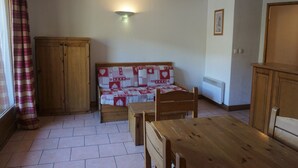 A room with a wooden bed, a wooden table, and a wardrobe. - 4-room apartment, 9 pers, pets allowed, covered parking (Orcières Merlette)
