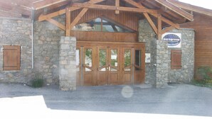 A building with a stone facade, wooden entrance, and a sign indicating it is part of the Eurogroup hotel chain. - 4-room apartment, 9 pers, pets allowed, covered parking (Orcières Merlette)