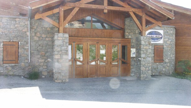 A building with a stone facade, wooden entrance, and a sign indicating it is part of the Eurogroup hotel chain. - Duplex for 7/8 people 50m from slopes, pets allowed and parking (Orcières Merlette)