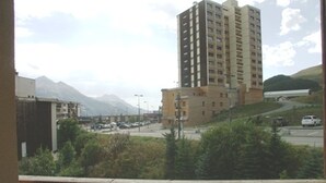 A high-rise building with multiple floors, surrounded by greenery and a mountainous backdrop. - Duplex for 7/8 people 50m from slopes, pets allowed and parking (Orcières Merlette)